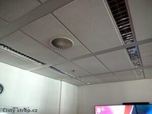 Čištění stropů a ventilace: Čistý podhled se svítidly a větracím výdechem v zasedací místnosti po úklidu.